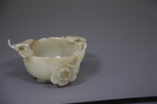A Chinese pale celadon jade lotus cup, late Ming dynasty, W.13cm, associated wood stand